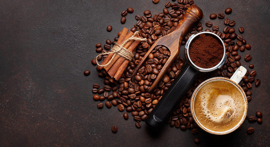 Café requentado faz mal ? Foto com tipos de grãos de café, canela em uma mesa preta.