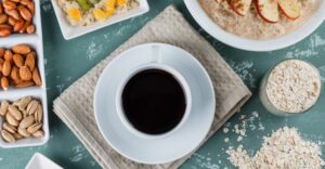 Café na Dieta - Xícara de café preto acompanhada de frutas, oleaginosas e aveia, ilustrando como o café pode fazer parte de uma alimentação equilibrada.
